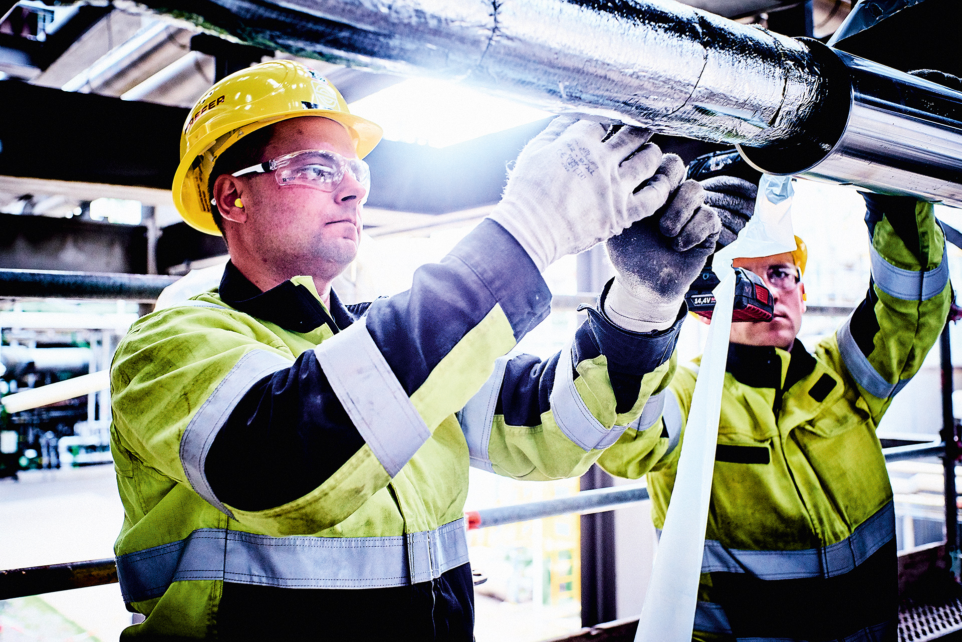 Industrie-Isolierer von KAEFER bei der Montage einer gedämmten Rohrleitung